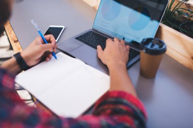 Eğitim ve öğrenim hakkında bilgi edinmek için internet sitesinde araştırma yapan yetenekli bir erkek öğrencinin görüntüsü, bilgisayar üzerinde not defteri yazan tanınmayan bir adam.