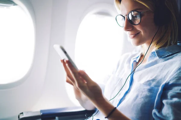 Erwachsene Frau Mit Telefon Mit Kopfhörer Während Sie Flugzeug Bequemen — Stockfoto