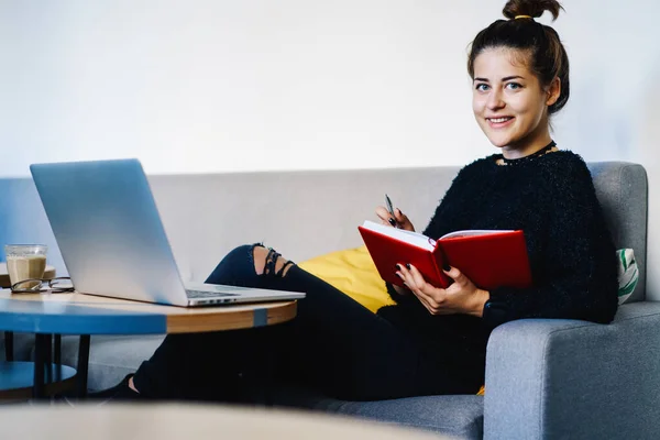 Sonriente Joven Estudiante Traje Casual Sentado Sofá Con Libro Lado — Foto de Stock