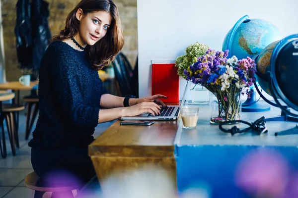 Joven Freelancer Mirando Cámara Mientras Está Sentada Mesa Cafetería Usando — Foto de Stock