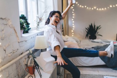 Kapalı gözlü, neşeli bir kadın ve duvarın yanında ayakta duran, bacağını kaldırmış, kollarını açmış, yatak odasında zaferle haykıran bir kadın.