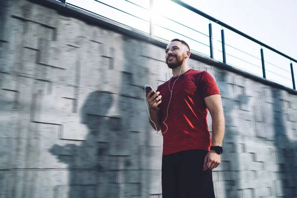 Bearded Male Red Shirt Using Phone Listening Music Looking Away — Stock Photo, Image