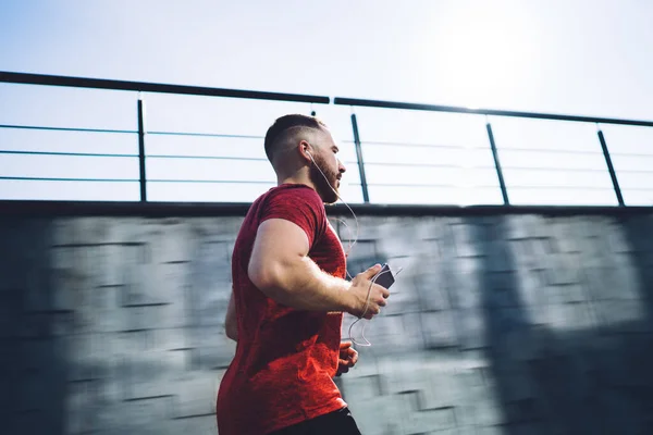 Vue Latérale Sportif Avec Smartphone Écouteurs Regardant Loin Courir Rapidement — Photo