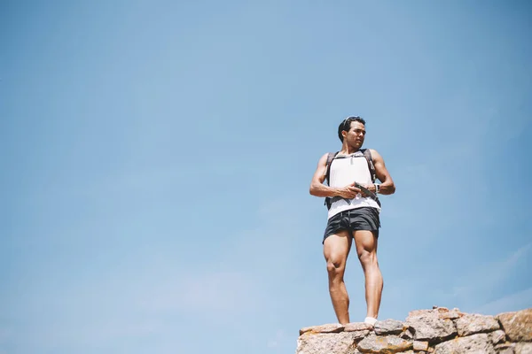 Young Male Athlete Sportswear Backpack Standing Rocky Cliff Looking Away — Stockfoto