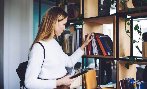 Widok Boku Młodej Kobiety Stojącej Nowoczesnej Bibliotece Poszukującej Literatury Plecaku — Zdjęcie stockowe