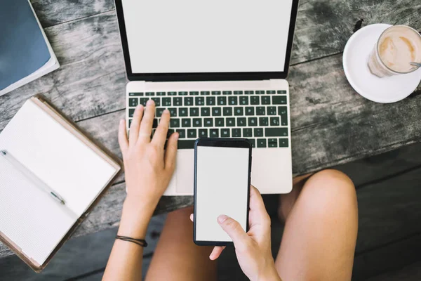 Cima Colheita Feminino Freelancer Surf Laptop Usando Smartphone Para Trabalho — Fotografia de Stock