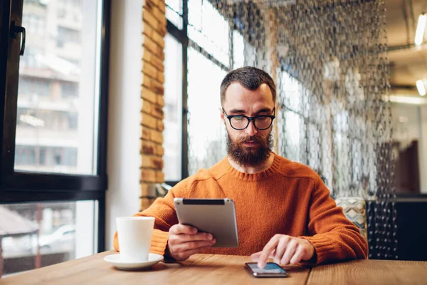 Hombre Concentrado Ropa Casual Sentado Mesa Con Tableta Taza Café — Foto de Stock