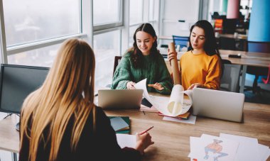 Masada elinde kağıtlar ve dizüstü bilgisayarlarla oturan bir grup genç bayandan yeni illüstrasyon fikrini düşünürken...