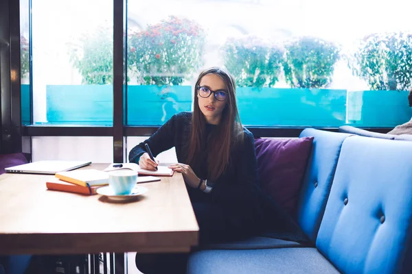 Young Concentrated Female Student Casual Outfit Looking Camera While Sitting — Foto Stock