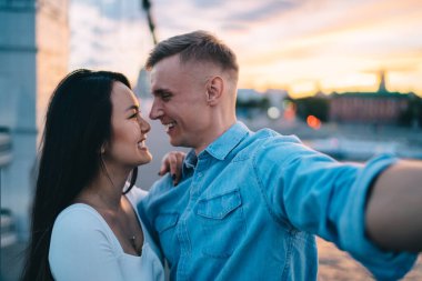 Neşeli erkek ve kadın kahkahalar atarak selfie çekiyorlar. Vlog 'u samimi bir ilişkiden tatmin ediyorlar. Gezici, neşeli hipster erkekler birbirlerine bakıp fotoğraf çekiyorlar.