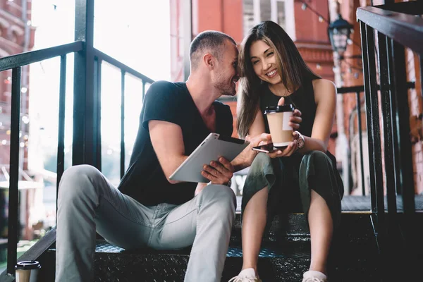 Cheerful Ethnic Couple Casual Clothes Sitting Stairs Browsing Tablet While — Stock Photo, Image