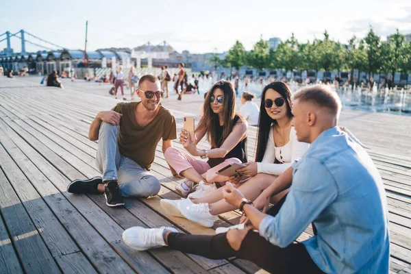 Modern Stylish Young People Communicating While Sitting Using Gadgets Park — Stockfoto