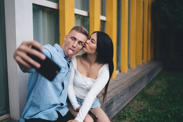 Alegre Macho Hembra Haciendo Muecas Divirtiéndose Mientras Mira Teléfono Inteligente —  Fotos de Stock