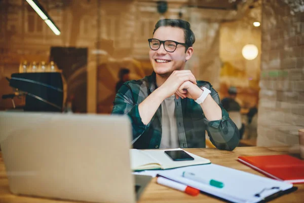 Cheerful Male Worker Casual Outfit Looking Away Sitting Wooden Table – stockfoto