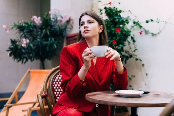 Serious Woman Classy Red Suit Cup Hot Beverage Hands Sitting — стоковое фото