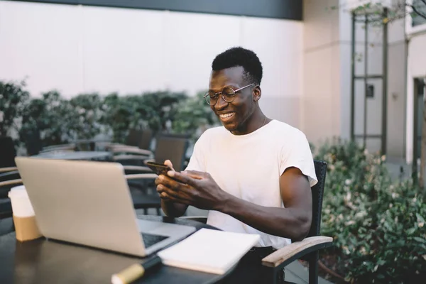 Schwarzer Junger Mann Lässigem Outfit Schreibt Sms Auf Smartphone Und — Stockfoto
