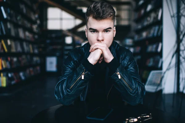 Contemplative Young Male Black Leather Jacket Sitting Table Modern Library — Stock Photo, Image