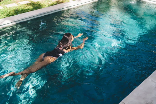 Felismerhetetlen Nyugodt Karcsú Hölgy Sötét Hajjal Fürdőruhában Úszás Kristályvízben Úszómedencében — Stock Fotó
