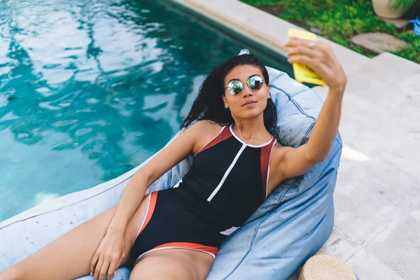 Young Female Swimsuit Sunglasses Taking Selfie While Lying Beanbag Lounge — Stock Photo, Image