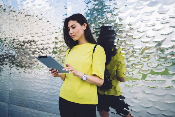Düşünceli Asyalı kadın dışarıda dikilip haber okuyor ve dijital tablet bildiriyor. Ciddi nüfuzlu hipster kız 20 'li yaşlarda touchpad ve 4G internet bağlantılarıyla video izliyor.