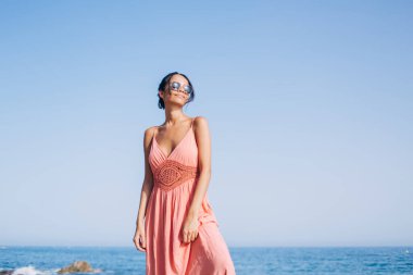 Yaz tatilleri boyunca Filipinler adasının deniz kıyısında dinlenmek için kaygısız kadın turist mutluluğu hisseder. Okyanusta uluslararası tatillerde hayal kuran güncel güneş gözlüklü Latin kız.