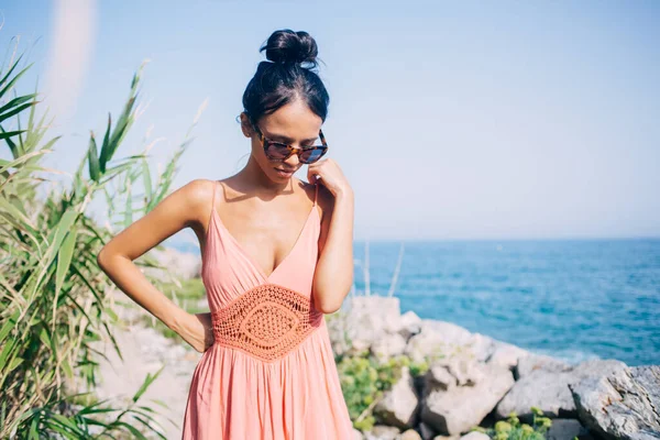 Güneş gözlüklü kaygısız bir Latin gezgin sahil şeridine bakıyor ve Filipinler adasında güneşlenmeyi düşünüyor. Gündelik giyinmiş güzel bir kadın uluslararası yaz tatilinin tadını çıkarıyor.