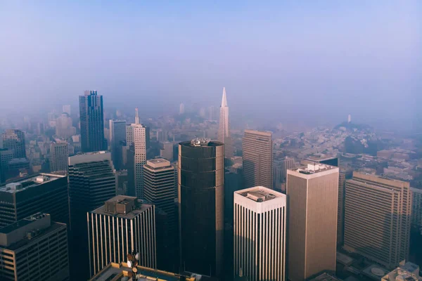 サンフランシスコの夕方に霧の空の下で高層ビルや通りと巨大な近代的な都市地区の空中ドローンビュー — ストック写真