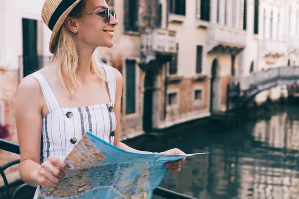 意大利暑假观光时带着纸质地图站在旁边看风景的时尚女性游客的侧视图 — 图库照片