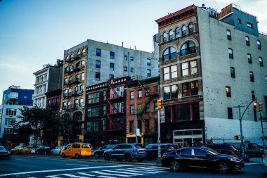 Mavi gökyüzüne karşı tuğla duvarları olan apartmanlar ve modern New York şehrimizde trafik sıkışıklığı