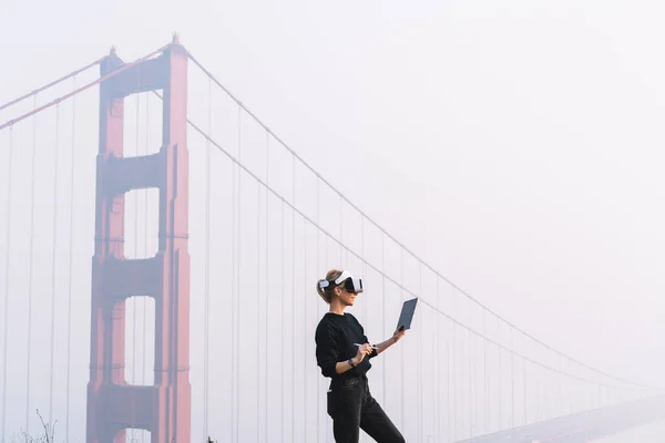 テストデバイスやゴールデンゲートブリッジ近くの霧のサンフランシスコでの時間を過ごすためにタブレットを使用してVrゴーグルの匿名女性 — ストック写真