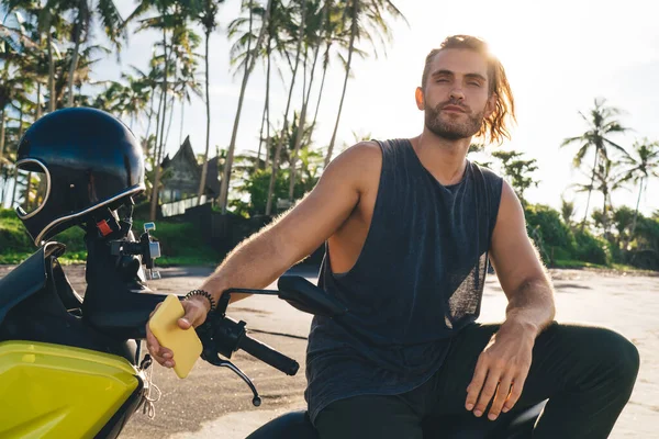 Motociclista Masculino Brutal Com Telefone Mão Sentado Bicicleta Olhando Para — Fotografia de Stock