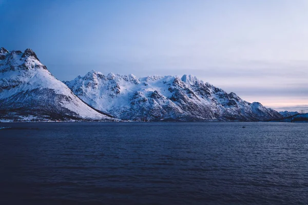 겨울해질 구름에 휩싸여 물결치는 근처에 바위투성이 노르웨이 피오르드 그림같은 — 스톡 사진