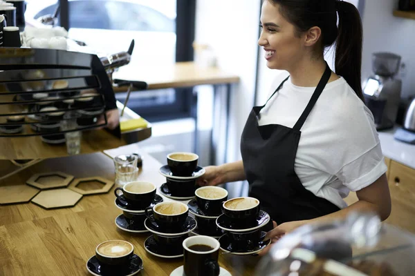 Cheerful Positive Woman Waitress Enjoying Serving Cafeteria Checking Cappuccino Cups — Fotografia de Stock