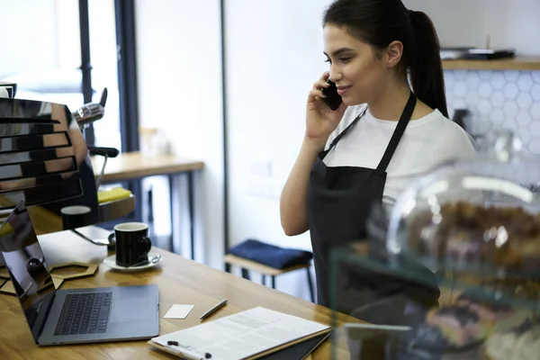 Professional Brunette Woman Apron Having Mobile Phone Conversation Discussing Business — стоковое фото