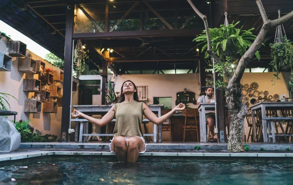 Friedliche Ethnische Frau Sitzt Rande Des Swimmingpools Mit Beinen Wasser — Stockfoto