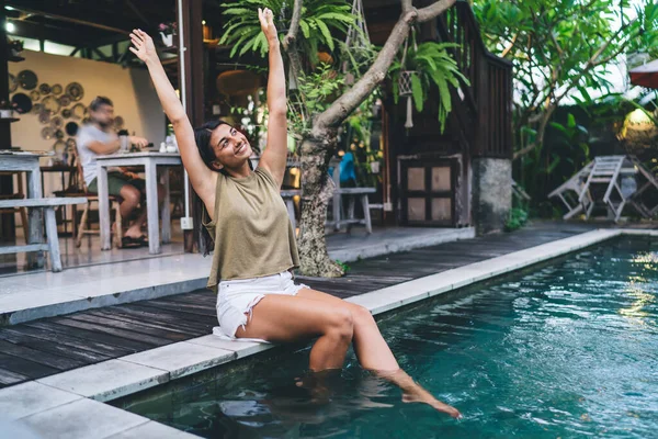 Etnis Wanita Ceria Dengan Tangan Terangkat Duduk Tepi Kolam Renang — Stok Foto