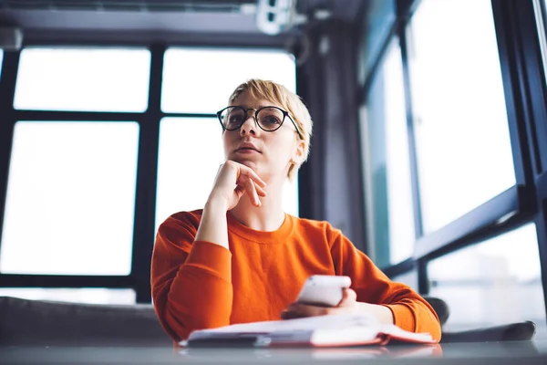 Low Angle Young Thoughtful Blond Female Orange Jumper Eyeglasses Surfing — Stockfoto