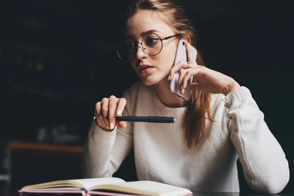 Mladý Soustředěný Student Konverzace Mobilním Telefonu Dělat Poznámky Notebooku Zatímco — Stock fotografie