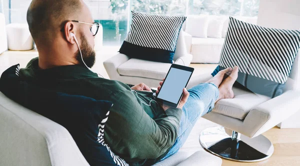 Achteraanzicht Van Een Jonge Serieuze Man Met Oortelefoon Die Tablet — Stockfoto