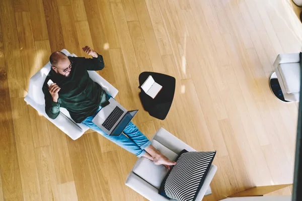 Surprised Male Freelancer Glasses Celebrating Success Browsing Netbook While Sitting — стоковое фото