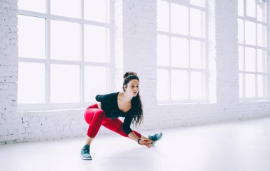 Beyaz tenli sporcu kadın vücut ve bacak antrenmanı sırasında antrenman yapıyor spor hedefleri doğrultusunda motive olmuş esmer kız spor salonunda egzersiz yaparken formunu koruyor.