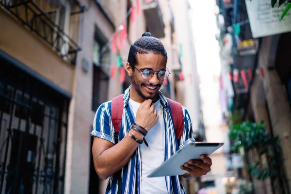陽気なアフリカ系アメリカ人のヒップスター男デジタルタブレット上のメッセージを読んで街をナビゲートするための方向性に関する情報を検索 笑顔暗い肌の男性ブロガーは ソーシャルネットワークでコンテンツを共有 — ストック写真