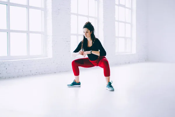 肉体トレーニング中の白人のスポーツ女性の練習体と足の筋肉 フィットネスの目標に動機づけられたアクティブなブルネットの女の子はジムスタジオで完璧な図形の練習を行う練習を維持 — ストック写真
