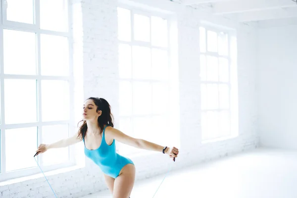 Attractive Female Athlete Blue Bodysuit Using Rope Cardio Exercising White — Stockfoto