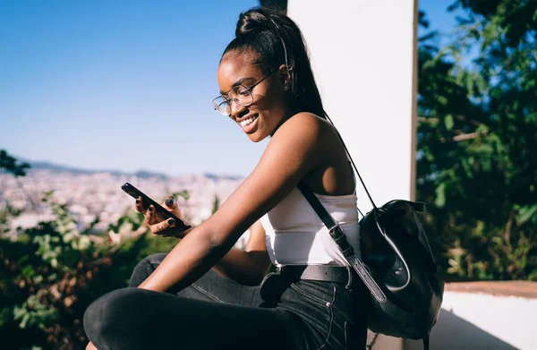 Happy African American Travel Blogger Enjoying Smartphone Messaging Network Followers — стокове фото