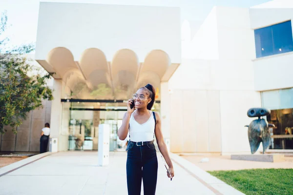 Joyful African American Student Leaving School Building Using Mobile Application — стокове фото