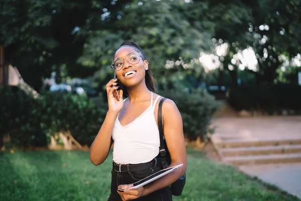 Koyu tenli neşeli hippi turist, elinde temasla arkadaşını arıyor. Gezici gezintiler hakkında konuşuyor. Optik gözlüklü mutlu siyah kadın uluslararası hücre sohbetinin tadını çıkarıyor.
