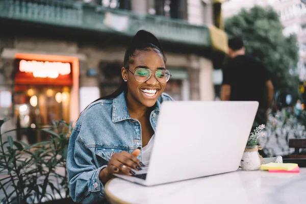 Joyful Dark Skinned Female Blogger Typing Text Publication Using Laptop — 图库照片