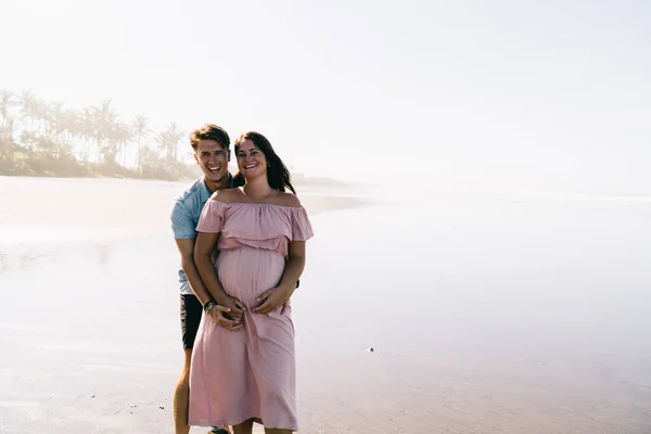 Gelukkige Jongeman Glimlachend Knuffelend Vrolijke Zwangere Vrouw Terwijl Samen Staan — Stockfoto