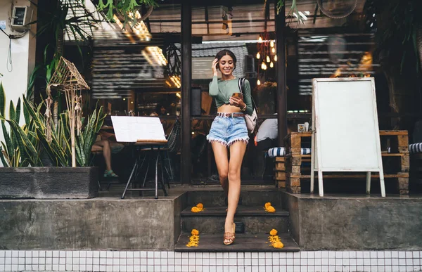 Corpo Inteiro Mulher Sorridente Roupa Moda Segurando Smartphone Tocando Cabelo — Fotografia de Stock